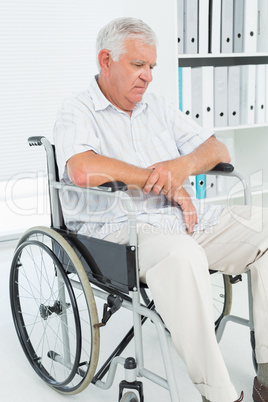 Sad senior man sitting in wheelchair