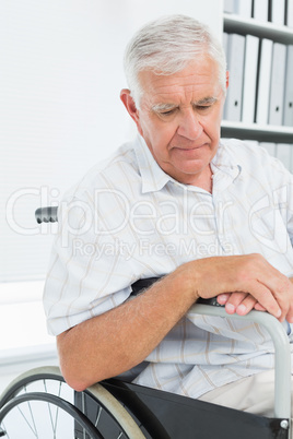 Side view of a sad senior man sitting in wheelchair