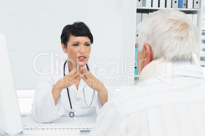 Female doctor attentively listening to senior patient