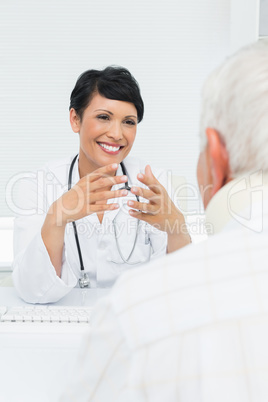 Young female doctor attentively listening to senior patient