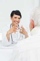 Young female doctor attentively listening to senior patient