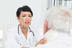 Female doctor examining a senior patients neck