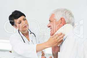 Female doctor examining a senior patients neck