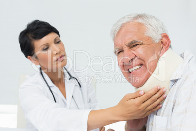 Female doctor examining a senior patients neck