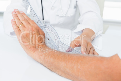 Physiotherapist examining patients wrist with goniometer