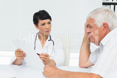 Female doctor showing reports to senior patient