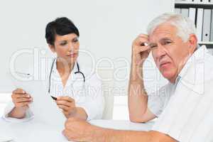 Doctor showing reports to worried senior patient