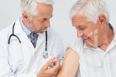 Doctor injecting senior male patient