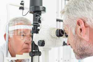 Optometrist doing sight testing for senior patient