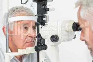 Optometrist doing sight testing for senior patient