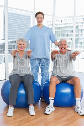 Female therapist assisting senior couple with exercises