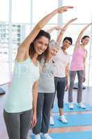 Class stretching hands at yoga class