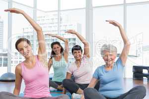 Class stretching hands at yoga class