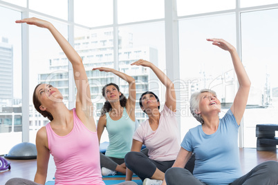 Class stretching hands at yoga class