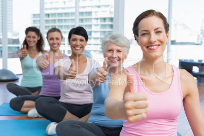 Women gesturing thumbs up in the yoga class