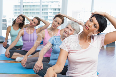 Class stretching neck in row at yoga class