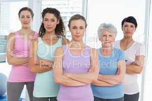 Confident women with arms crossed in yoga class