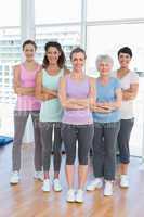 Happy women with arms crossed in yoga class