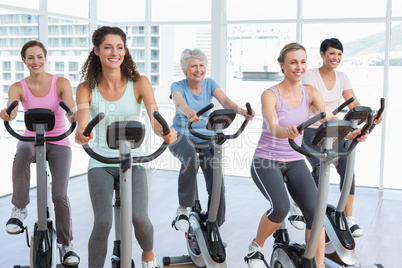 Happy women working out at spinning class Happy women working out at spinning class