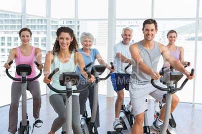 Happy people working out at spinning class