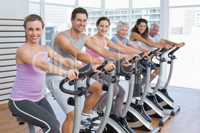 Happy people working out at spinning class