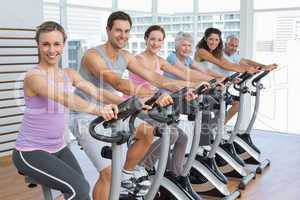 Happy people working out at spinning class