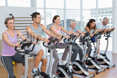 Happy people working out at spinning class