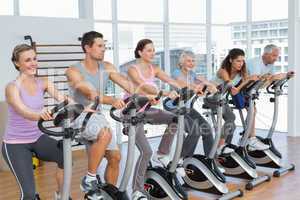 Happy people working out at spinning class