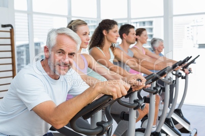 People working out at spinning class in gym