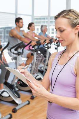 Trainer with people working out at spinning class