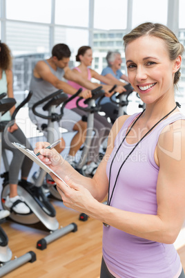 Trainer with people working out at spinning class