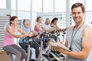 Trainer with people working out at spinning class