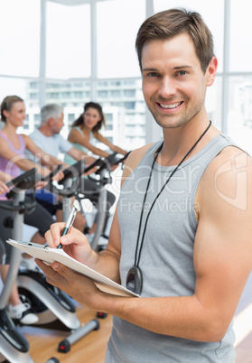 Trainer with people working out at spinning class