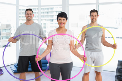 Fitness class holding hula hoops in gym