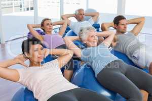 Sporty people stretching on exercise balls
