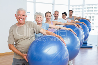 Sporty people carrying exercise balls in bright gym