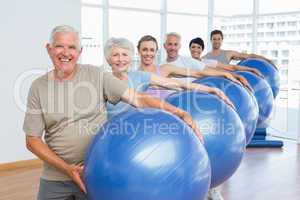 Sporty people carrying exercise balls in bright gym