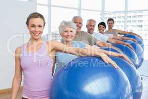 Portrait of sporty people carrying exercise balls in gym