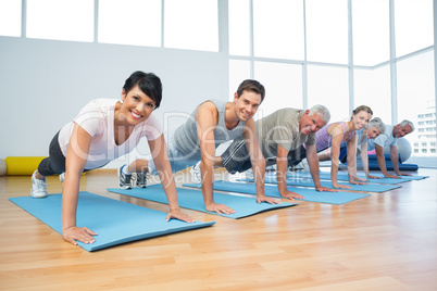 Group doing push ups in row at yoga class