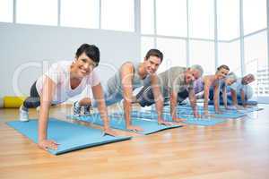 Group doing push ups in row at yoga class