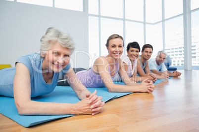 Fitness group lying in row at yoga class