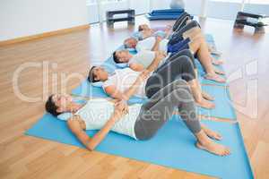 Class resting on mats in row at yoga class