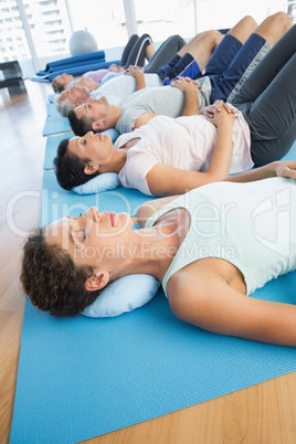 Class resting on mats in row at yoga class