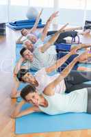 Fitness class stretching legs and hands in row