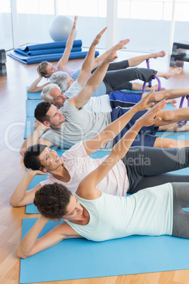 Fitness class stretching legs and hands in row