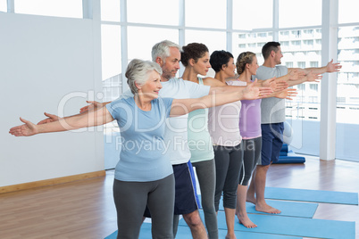 Class stretching hands in row at yoga class