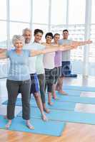 Class stretching hands in row at yoga class