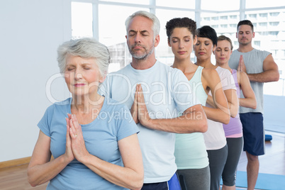 Sporty people with eyes closed and joined hands