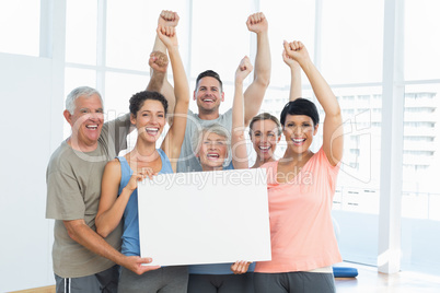 Portrait of happy fit people holding blank board