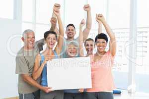 Portrait of happy fit people holding blank board